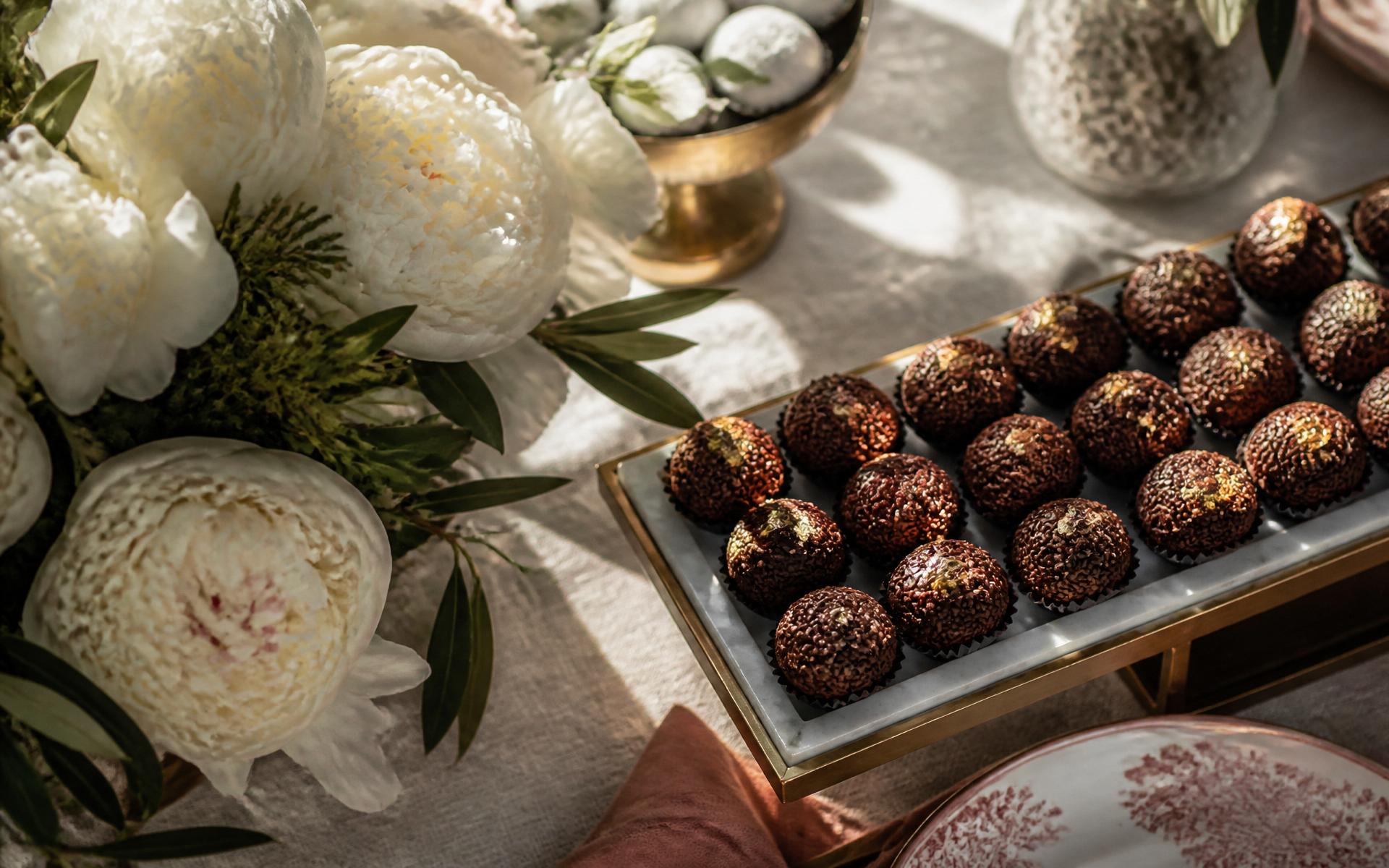 Mesa posta com brigadeiros artesanais e peónias